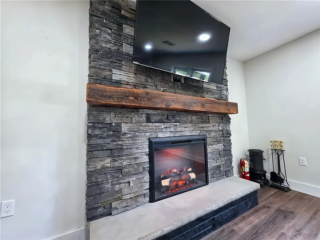 Finished Greenhurst stone fireplace with a timber mantel